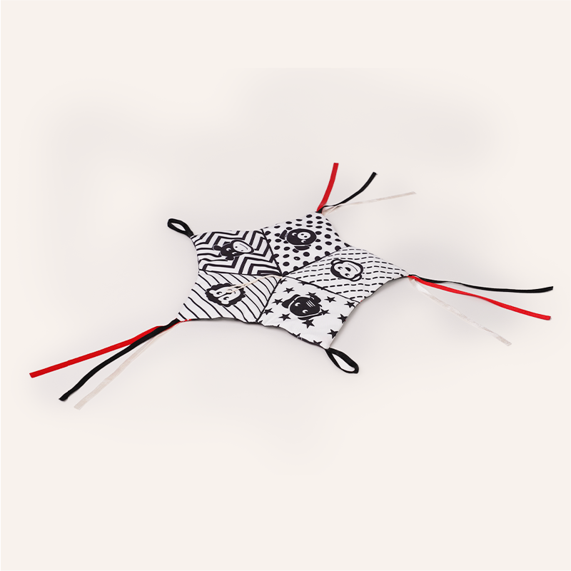 Black and white patterned face mask with red straps on a white background