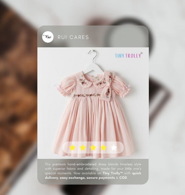 Pink dress on a hanger with 'Tiny Tolly' branding on a blurred background